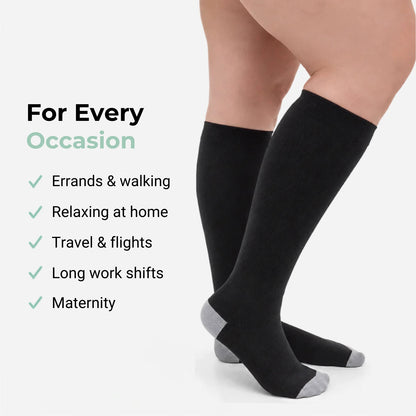 Black knee-high socks with gray accents worn by a person, displayed against a white background.